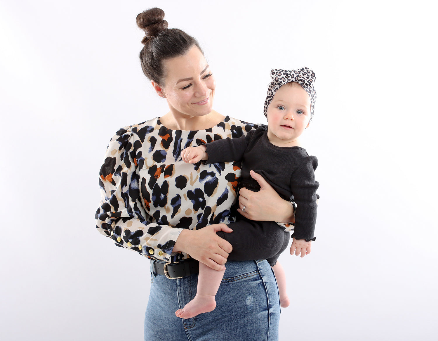 Breastfeeding mum wearing a stylish leopard print breastfeeding top with zips for discreet and easy nursing access. Fashionable top on Mum allows her to breastfeed in style. Mum looking at breastfed baby, breastfeeding blouse looks gorgeous on her. 